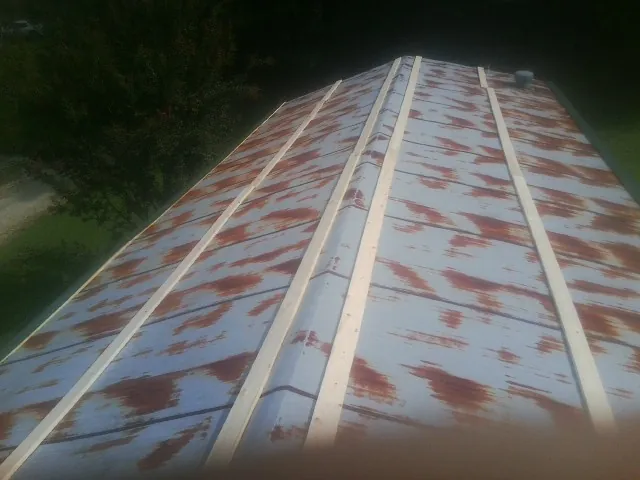 Rusted metal roof panels with new wood purlins before replacement — Storm Damage Roof Repair in Harvest by Roofing Brothers