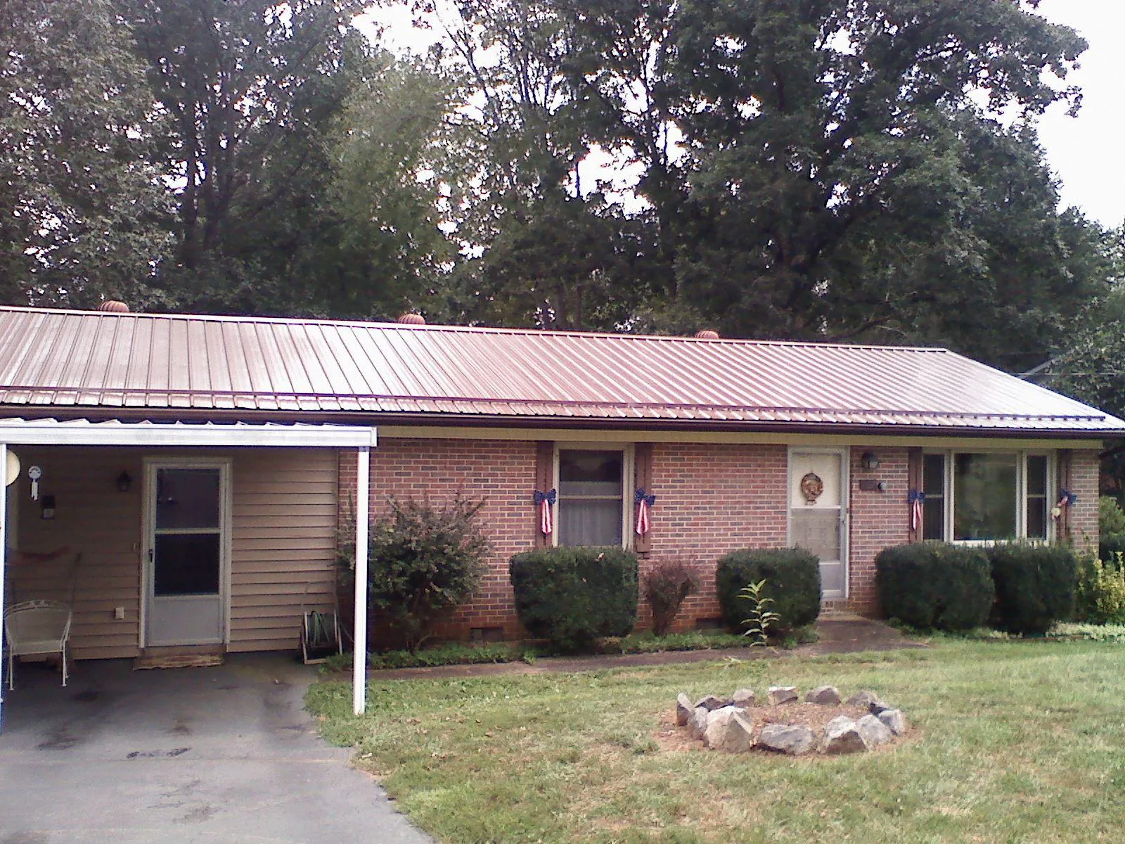Bronze metal roof and carport on a brick ranch home — Roof Repair work by our crew in Harvest